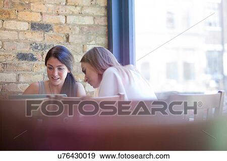 Stock Photo - Businesswomen having meeting in coffee bar, London. Fotosearch