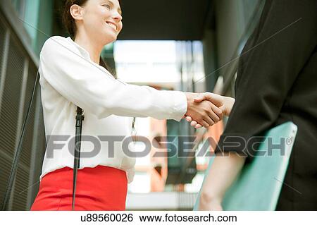 Stock Photograph - Businesswomen shaking hands at meeting, London. Fotosearch