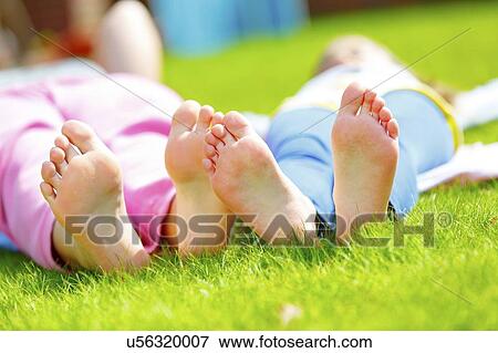 Stock Photo - Children lying down on the grass. Fotosearch