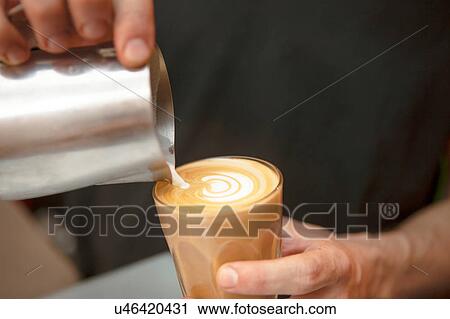 Close up of barista's hands pouring milk into coffee in cafe View Large Photo Image Stock Image - Close up of barista's hands pouring milk into coffee in cafe. Fotosearch