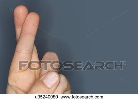 Stock Image - Close-up of hand with fingers crossed. Fotosearch