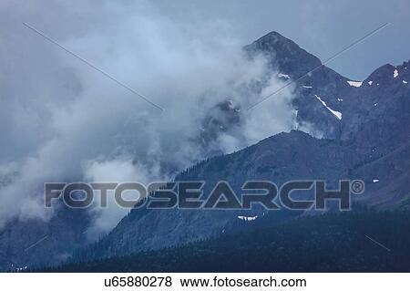Stock Photo - Clouds with Mountains and green trees - San Juan Mountains, Colorado, USA. Fotosearch