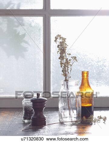Stock Image - Condiments and vase on windowsill. Fotosearch