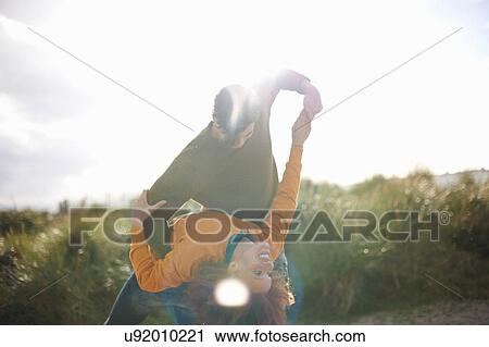 Stock Image - Couple dancing on grassy sand dune. Fotosearch