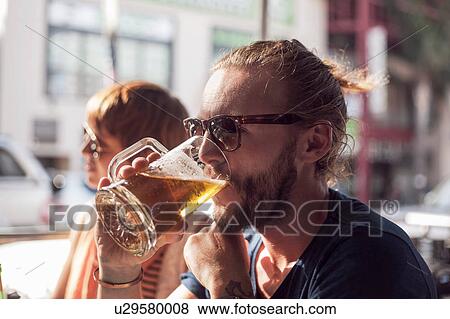 Stock Photo - Couple drinking beer at sidewalk cafe, Cape Town, South Africa. Fotosearch