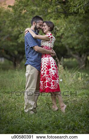 Stock Image - Couple embracing in cherry orchard. Fotosearch