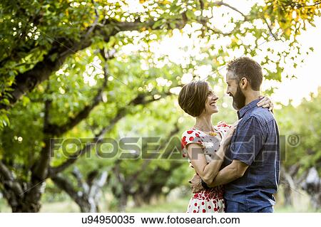 Stock Photography - Couple embracing in cherry orchard. Fotosearch