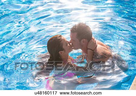 Stock Photo - Couple in swimming pool kissing. Fotosearch