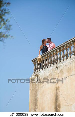 Couple kissing on rooftop balcony at boutique hotel, Majorca, Spain View Large Photo Image Stock Photo - Couple kissing on rooftop balcony at boutique hotel, Majorca, Spain. Fotosearch