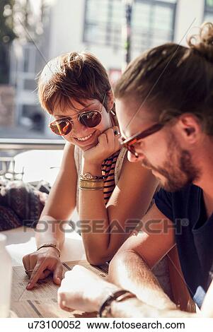 Couple reading menu at sidewalk cafe View Large Photo Image Stock Image - Couple reading menu at sidewalk cafe. Fotosearch
