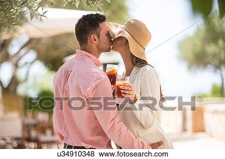 Stock Photo - Couple sharing a kiss on arrival to boutique hotel, Majorca, Spain. Fotosearch