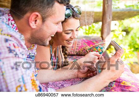 Stock Photo - Couple using digital tablet smiling. Fotosearch
