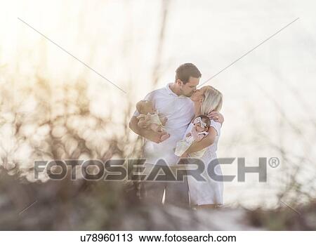 Couple with twins (2-5 months) kissing and holding View Large Photo Image Stock Image - Couple with twins (2-5 months) kissing and holding. Fotosearch