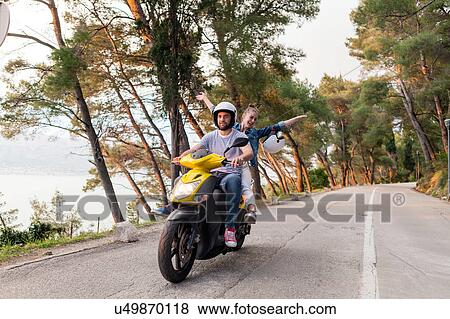Couples riding moped on rural road, Split, Dalmatia, Croatia View Large Photo Image Stock Photo - Couples riding moped on rural road, Split, Dalmatia, Croatia. Fotosearch
