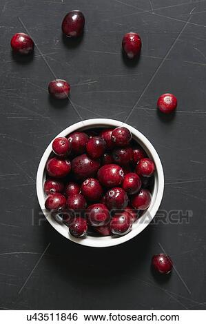 Stock Photograph - Cranberries in bowl and on table. Fotosearch