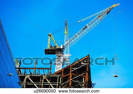 Stock Image - Crane at construction site against clear sky. Fotosearch