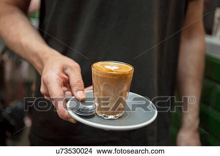 Picture - Cropped shot of barista holding glass of coffee in cafe. Fotosearch