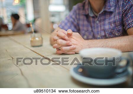 Picture - Cropped shot of man at coffee shop table. Fotosearch