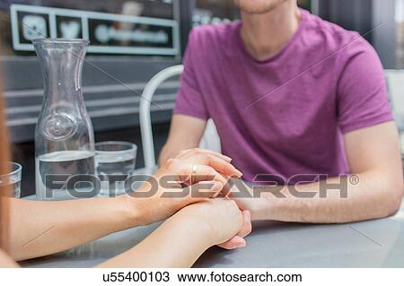 Cropped shot of mid adult couple holding hands at city sidewalk cafe View Large Photo Image Stock Image - Cropped shot of mid adult couple holding hands at city sidewalk cafe. Fotosearch