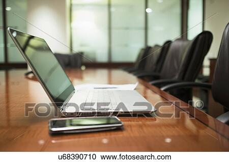 Stock Image - Empty conference table with mobile devices. Fotosearch