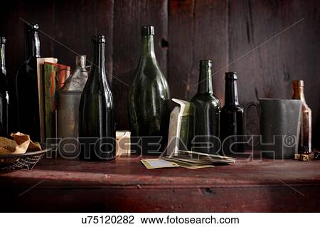 Empty vintage beer bottles and playing cards on pub shelf View Large Photo Image Stock Image - Empty vintage beer bottles and playing cards on pub shelf. Fotosearch