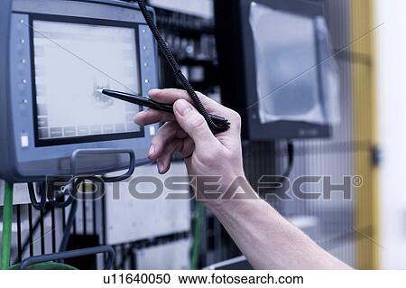 Stock Image - Engineer in engineering plant, using stylus on screen, close-up. Fotosearch