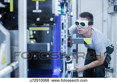 Engineer, wearing safety goggles, working in engineering plant View Large Photo Image Stock Photo - Engineer, wearing safety goggles, working in engineering plant. Fotosearch
