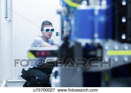 Stock Photo - Engineer, wearing safety goggles, working in engineering plant. Fotosearch
