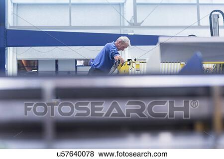 Stock Photo - Engineer working in engineering plant. Fotosearch