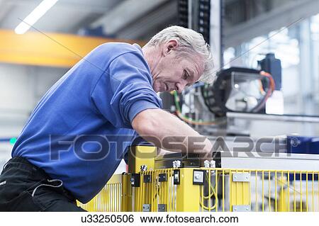 Stock Photograph - Engineer working in engineering plant. Fotosearch