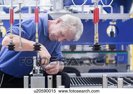 Stock Photography - Engineer working on electrical component controls in engineering plant. Fotosearch