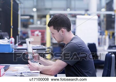 Stock Photo - Engineer working on metal rail in engineering plant. Fotosearch