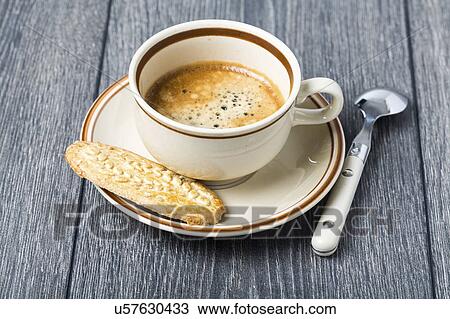 Stock Image - Espresso in coffee cup with biscuit. Fotosearch