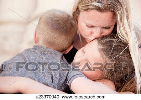 Stock Image - Family hugging and kissing. Fotosearch
