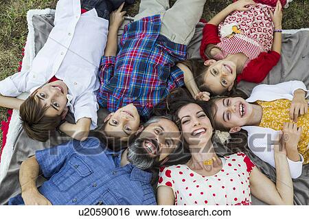 Stock Photograph - Family lying on grass. Fotosearch