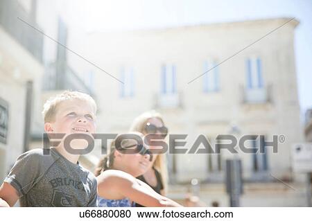 Stock Image - Family sitting in Piazza S. Oronzo, Lecce, Italy. Fotosearch