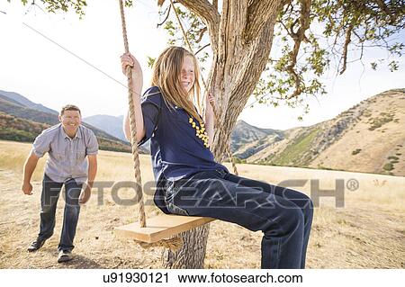 Father with daughter (8-9) sitting on swing View Large Photo Image Stock Image - Father with daughter (8-9) sitting on swing. Fotosearch