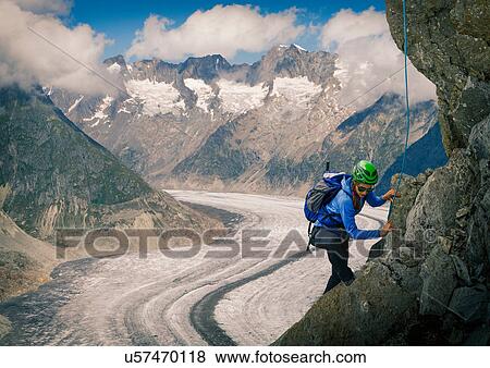 Female climber climbing rock face over Aletsch Glacier, Canton Wallis, Switzerland View Large Photo Image Stock Photo - Female climber climbing rock face over Aletsch Glacier, Canton Wallis, Switzerland. Fotosearch
