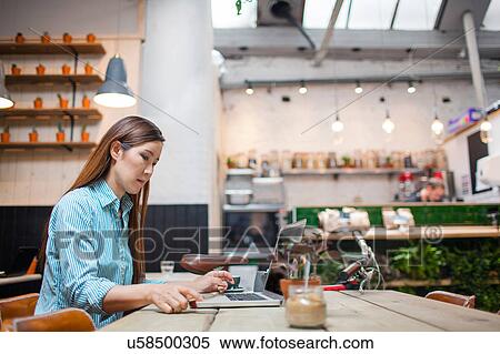 Female customer typing on laptop in cafe View Large Photo Image Stock Photography - Female customer typing on laptop in cafe. Fotosearch