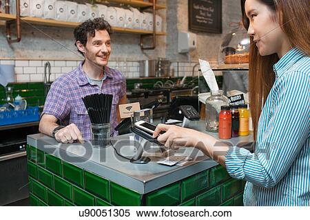 Female customer using smartphone contactless payment in cafe View Large Photo Image Stock Photography - Female customer using smartphone contactless payment in cafe. Fotosearch