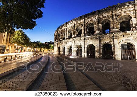 Stock Image - France, Occitanie, Nimes, Arena of Nimes at dusk. Fotosearch