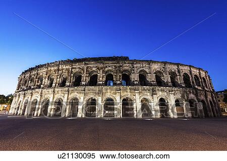 Stock Photography - France, Occitanie, Nimes, Arena of Nimes at dusk. Fotosearch
