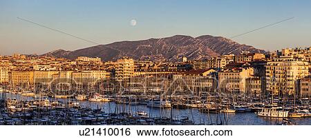 Stock Photograph - France, Provence-Alpes-Cote d'Azur, Marseille, Cityscape with Vieux port - Old Port, mountain in background. Fotosearch