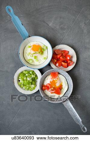 Fried eggs and vegetables on frying pans and plates View Large Photo Image Stock Image - Fried eggs and vegetables on frying pans and plates. Fotosearch