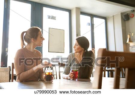 Stock Image - Friends enjoying drinks in pub, London. Fotosearch