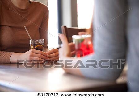 Stock Image - Friends enjoying drinks in pub, London. Fotosearch