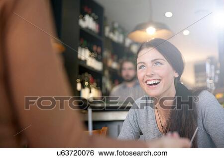 Stock Photograph - Friends enjoying drinks in pub, London. Fotosearch