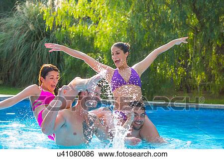 Stock Photograph - Friends fooling around in swimming pool. Fotosearch