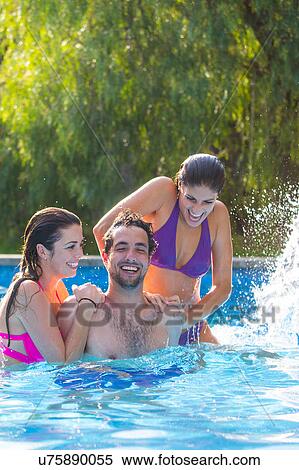 Stock Photography - Friends fooling around in swimming pool. Fotosearch