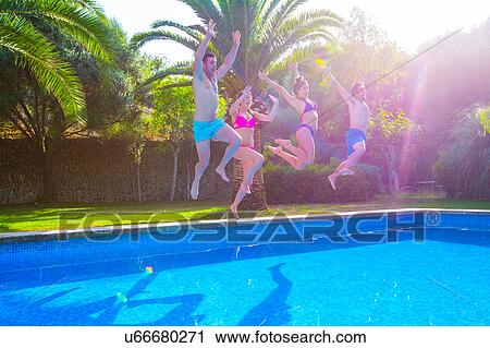 Stock Image - Friends jumping in swimming pool together. Fotosearch